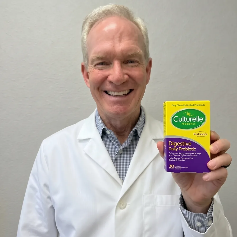 A physician in a white coat smiling and holding up the Culturelle Digestive Daily Probiotic carton.