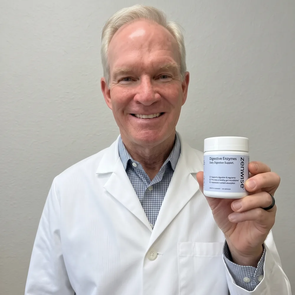 A physician in a white coat smiling and holding up the Zenwise Digestive Enzymes jar.